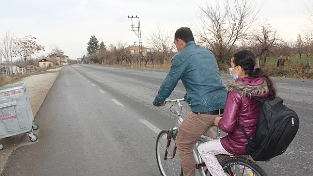 Fedakar baba, yürüyemeyen kızını okula bisikletiyle götürüyor